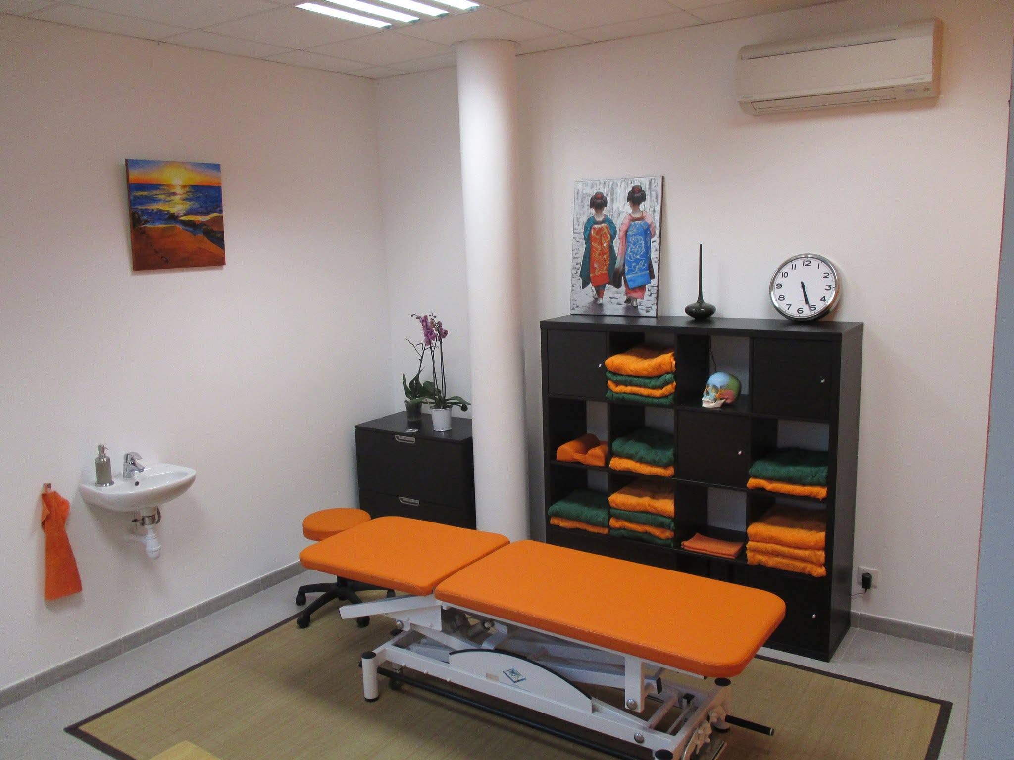 Salle de consultation lumineuse du cabinet avec table de soin orange