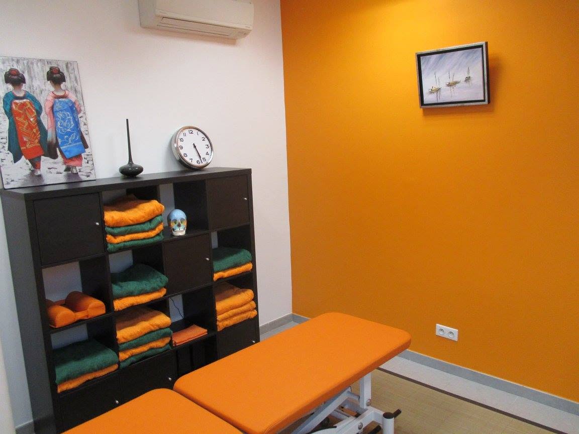Espace de soin du cabinet avec mur orange et linge de consultation